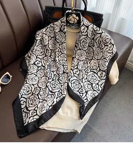 Dettaglio ravvicinato di una sciarpa con stampa floreale camelia e accessori moda eleganti