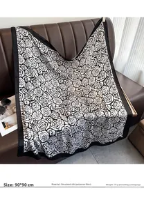 Dettaglio della sciarpa in seta 90x90cm con stampa camelia drappeggiata sul divano