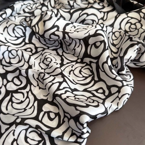 Elegante sciarpa in seta con stampa a camelia bianca e nera e finitura satinata lucida e fluida