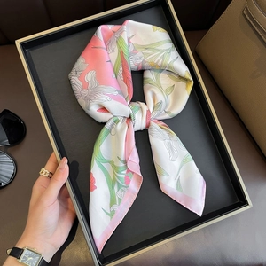 Elegant floral silk scarf in pastel colors displayed on a luxury black minimalist tray