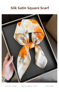 Detail of silk-satin square scarf with orange floral print on elegant display