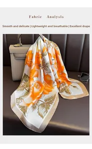 Detail of floral silk scarf on leather bag showing smooth texture and drape