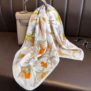70cm floral silk square scarf in orange and yellow draped on a luxury handbag