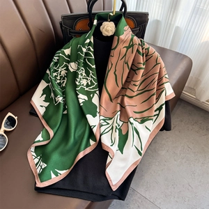 Close-up of vintage floral silk scarf draped over a black sweater with retro style