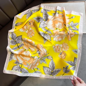 Detailed macro view of the yellow rose pattern on a 70cm silk square scarf fabric