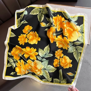 Detailed macro of floral pattern on 70cm black silk-like scarf with yellow roses