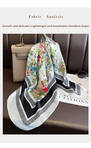 Detail of floral printed silk scarf draped on a leather handbag with fashion accessories