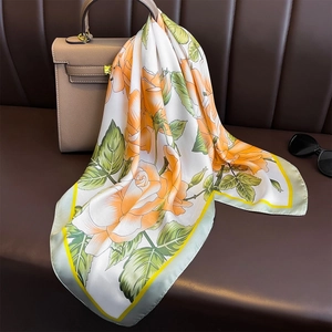 70cm floral silk scarf with orange roses tied on a stylish handbag in a fashion setting