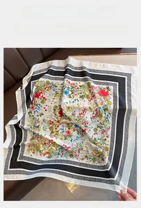 Detailed flat lay of a floral silk scarf with colorful prints on a leather surface