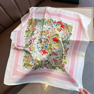 Detailed view of silk square scarf featuring colorful floral print and striped borders