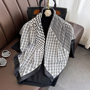 Detail of classic houndstooth and geometric silk scarf with black wide border