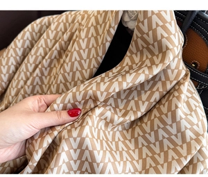 Detail view of the V-pattern twill silk scarf with smooth texture and soft drape