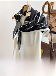 Detailed view of black and white polka dot silk scarf draped over a white dress