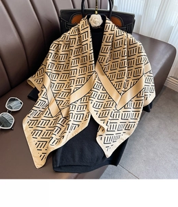 Detail of elegant beige and black geometric striped silk scarf on a hanger display