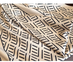 Macro shot of striped twill silk scarf showing smooth texture and geometric patterns