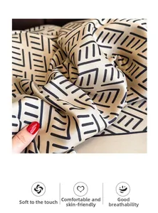 Macro shot of soft champagne silk scarf with geometric patterns showing skin-friendly texture