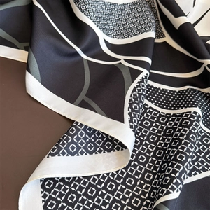 Macro shot of twill silk scarf showing geometric black and white patterns and fine hem
