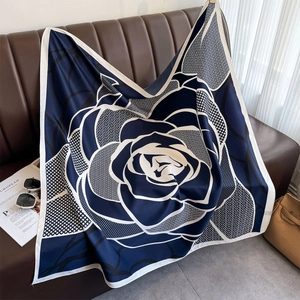 Detailed close-up of dark blue and white silk scarf with elegant large rose floral pattern