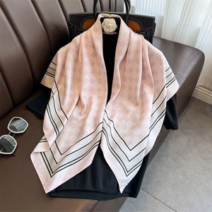 Eleganter rosa Seidenschal mit Blumenmuster und geometrischem Rand auf dem Sofa drapiert