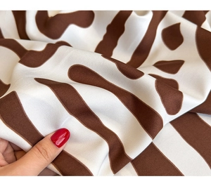 Macro shot of twill silk scarf showing smooth texture and brown zebra print pattern