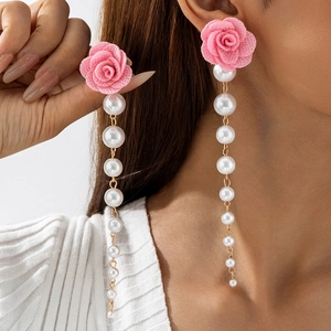 Detail of elegant pink fabric rose earrings with long faux pearl fringe tassels