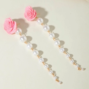 Detailed view of pink fabric rose and cascading white pearl tassel drop earrings