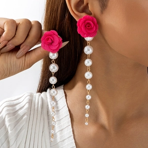 Detail of tulip fabric flower earrings with white faux pearl tassels on model
