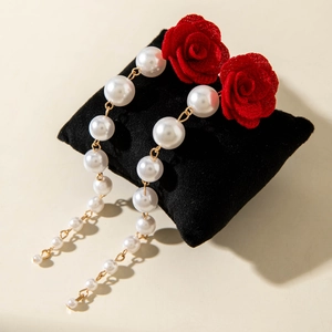 Detail view of red rose earrings with gradient faux pearls and gold chain links
