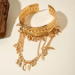 Détail d'un bracelet de bras bohème doré avec gravure triangle et chaîne à franges