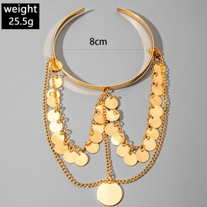 Détail d'un bracelet de bras doré style western avec franges en métal et sequins