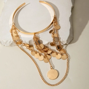 Détail d'un bracelet de bras doré avec de longues chaînes et des pendentifs