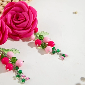 Pink satin camellia flower earrings with long green beaded tassels in a summer style