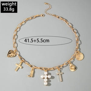 Macro detail of western necklace with cowboy hat, cross, and boot charms in gold finish