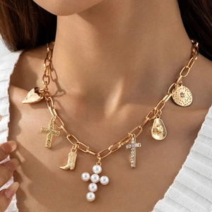 Detail of bohemian gold chain necklace with western cowboy hat and cross pendants