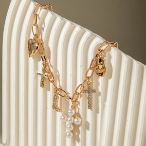 Golden chunky chain necklace with cowboy hat, cross, and pearl heart charms