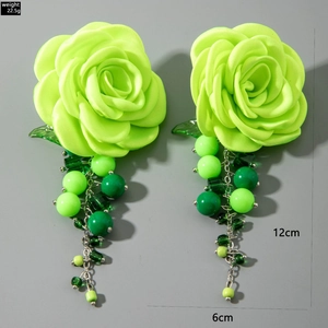 Macro shot of green flower earrings with acrylic tassels and detailed dimensions