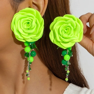 Close-up of neon green camellia fabric earrings with beaded fringe tassels on model
