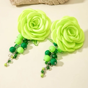 Macro detail of camellia earring with satin neon green petals and beaded tassels