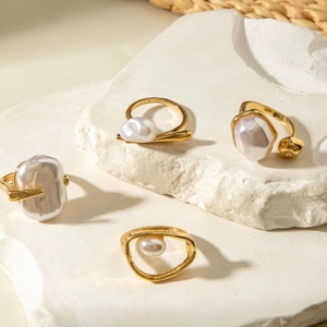 Set of four minimalist gold geometric rings featuring unique baroque pearls on stone