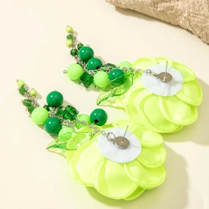 Detailed view of neon green camellia flower earrings with acrylic beads and metal chain