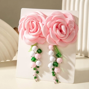 Detail of pink silk camellia flower earrings with colorful beaded tassels and crystal leaves