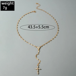 Dettaglio della collana a croce dorata con catena a maglie e accenti in cristallo
