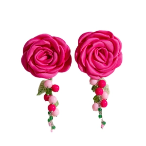 Fuchsia satin rose earrings with acrylic beads and green leaf tassels on white background