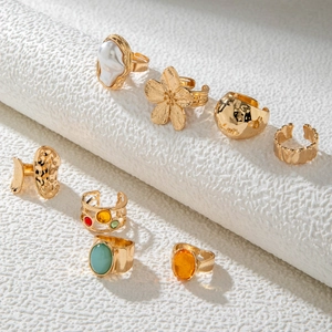 Set of 8 vintage gold-plated rings with pearls, flowers and colorful gemstones on white stand
