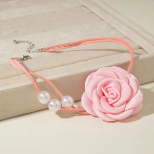 Elegant pink satin rose choker necklace with white pearls on a velvet jewelry display box