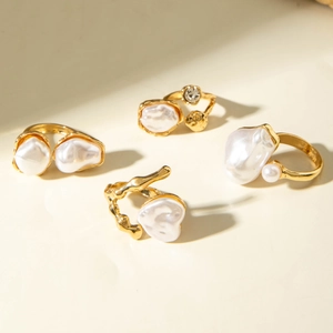 Detail view of four gold-plated baroque pearl rings with irregular organic textures
