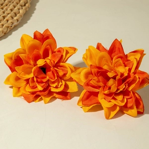 Close-up of bohemian orange gradient fabric flower earrings with layered petals