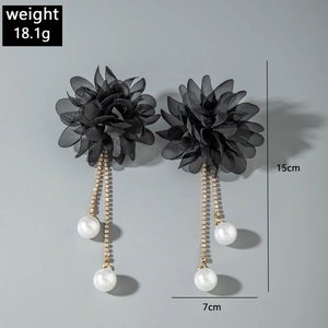 Detail view of floral tassel earrings with black fabric petals and white faux pearls