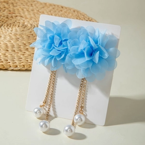 Detailed view of light blue tulle flower earrings with pearl tassels and rhinestones