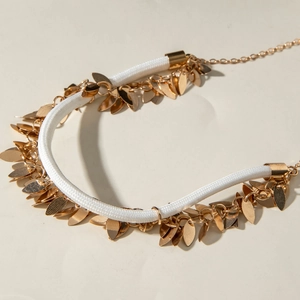 Ethnic style necklace with white braided cord and dense golden leaf pendants